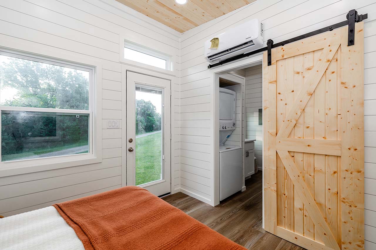 Kingdom L Combo: Spacious master bedroom with modern barn doors. Enjoy a comfortable sleeping retreat in your tiny home. 